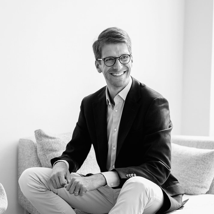 Michael Repnik, CEO von LearnChamp im Anzug auf einem Sofa