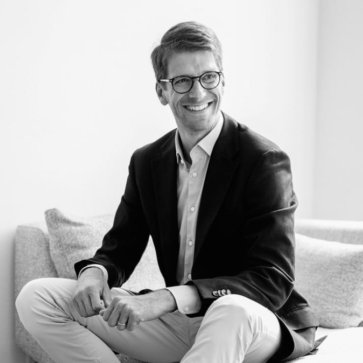 Michael Repnik, CEO & Founder - Learnchamp, im Anzug am Sofa