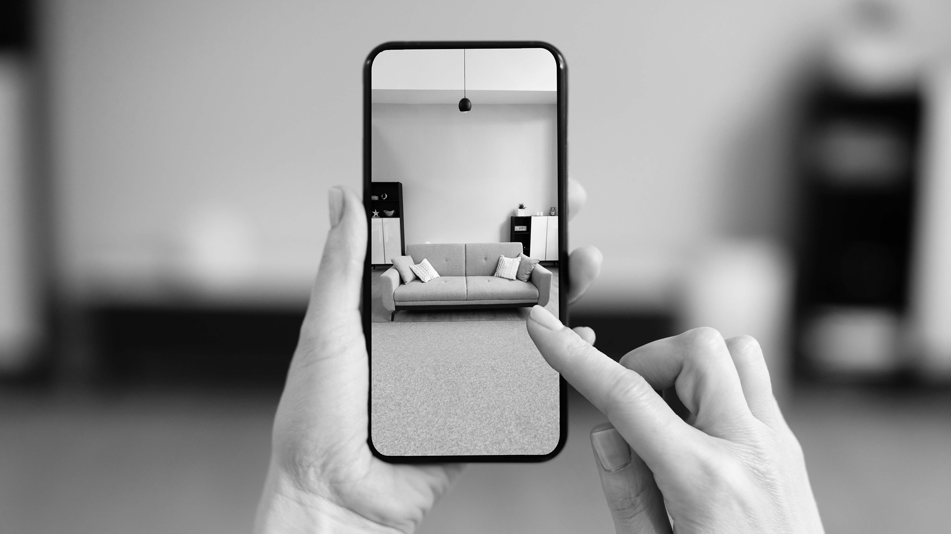 Smartphone zeigt eine mittels AR in den Raum projizierte Couch